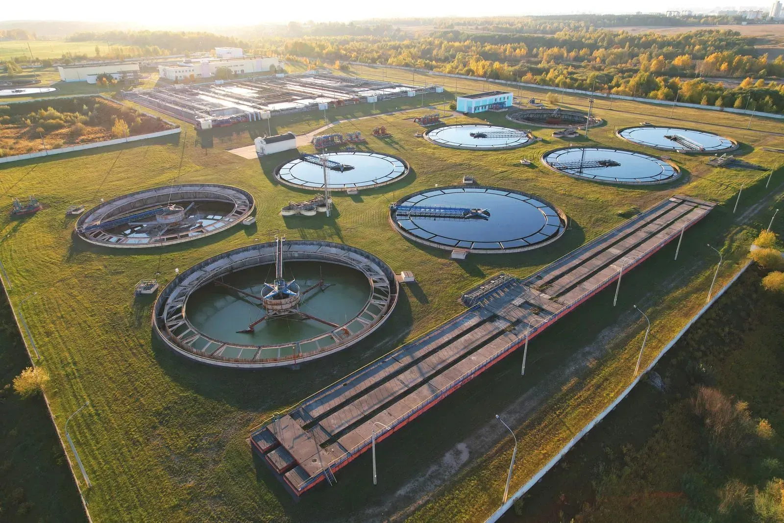 An aerial view of a water treatment plant with a lot of tanks filled with water.