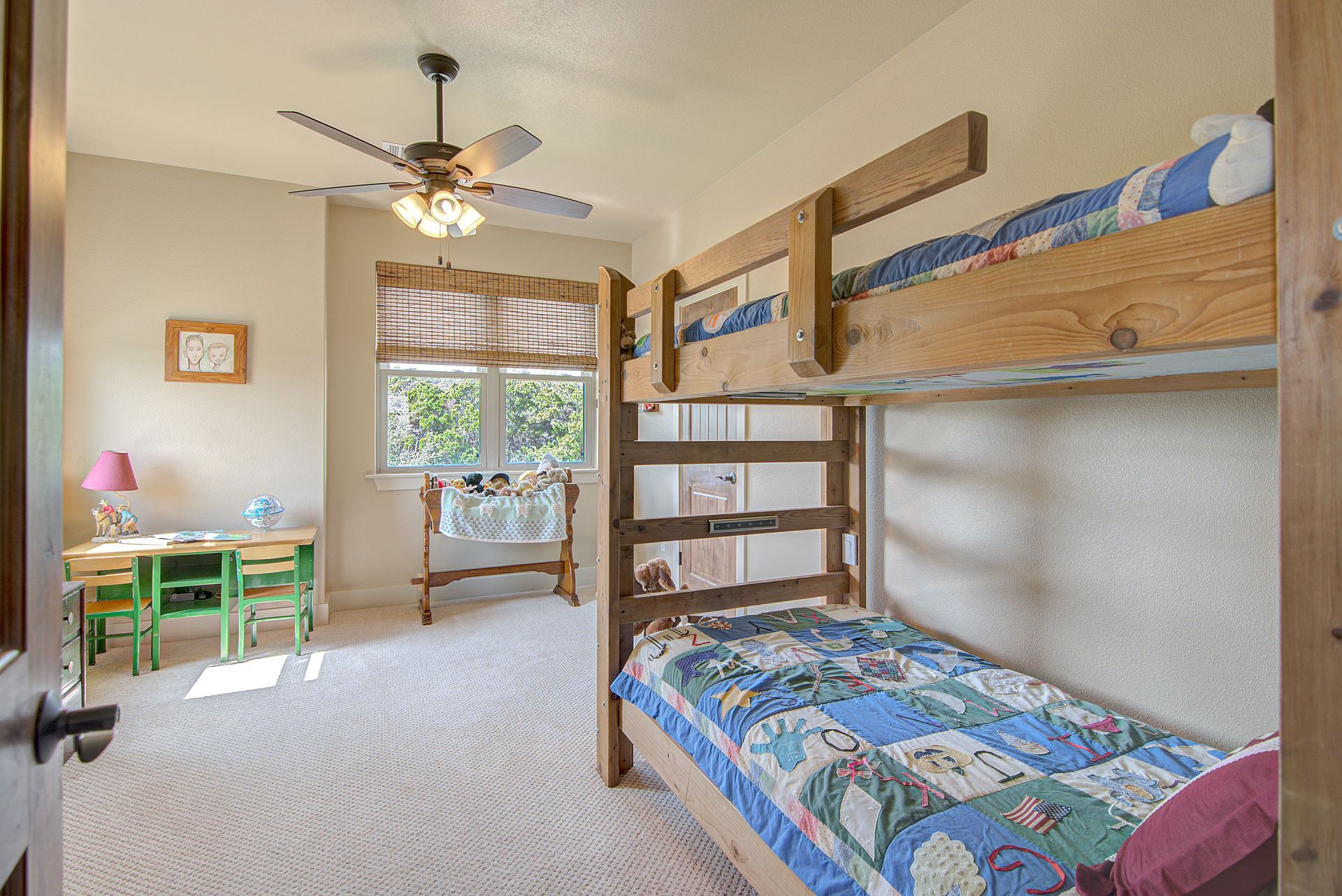 A bedroom with two bunk beds and a ceiling fan.
