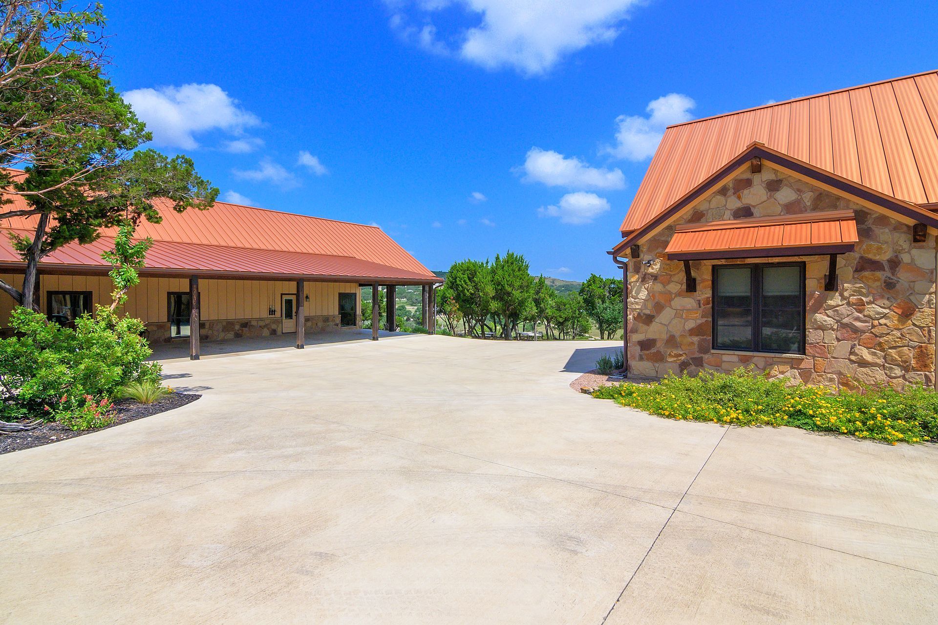 A driveway leading to two houses with red tile roofs