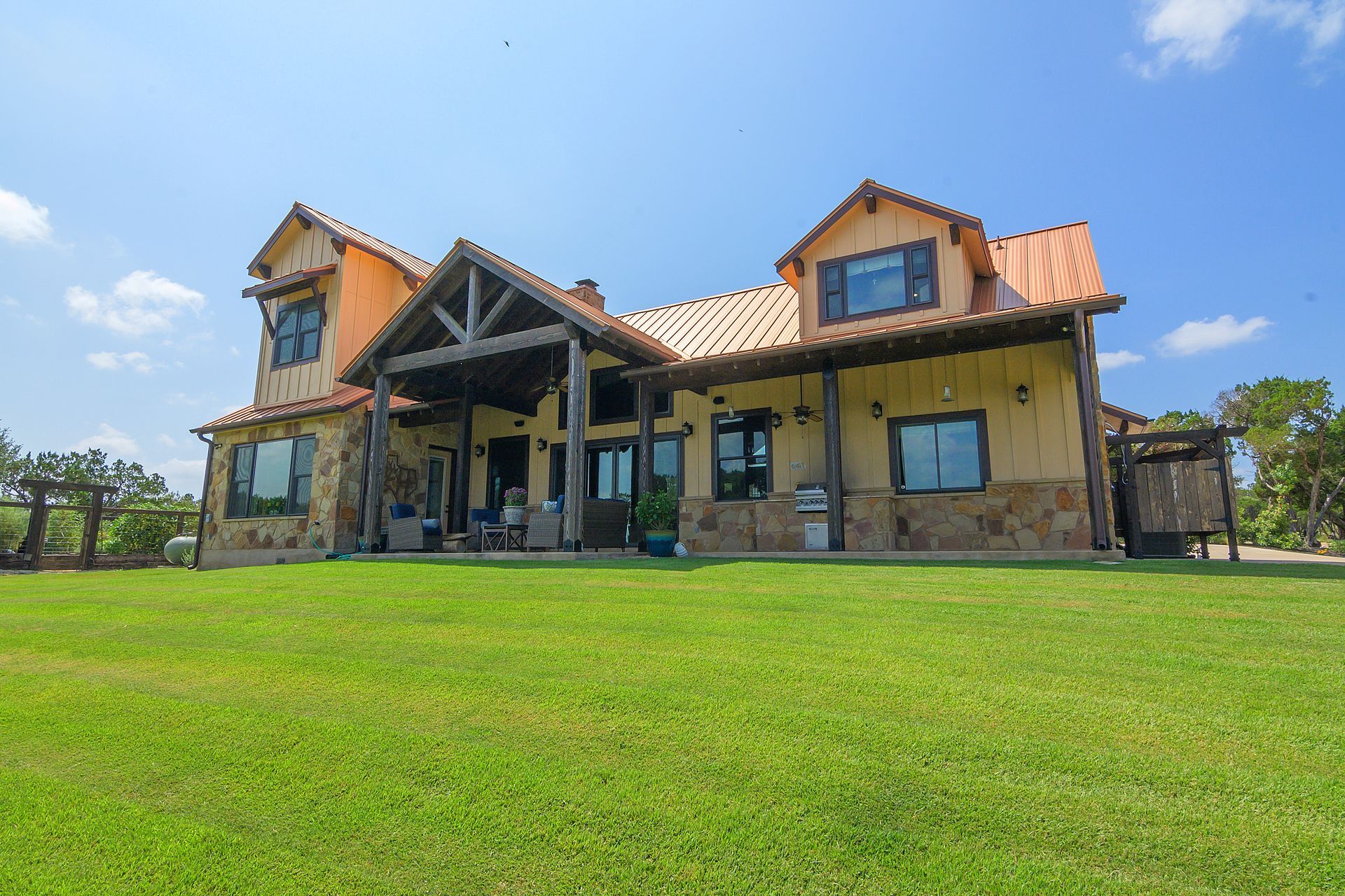 A large house is sitting on top of a lush green field.