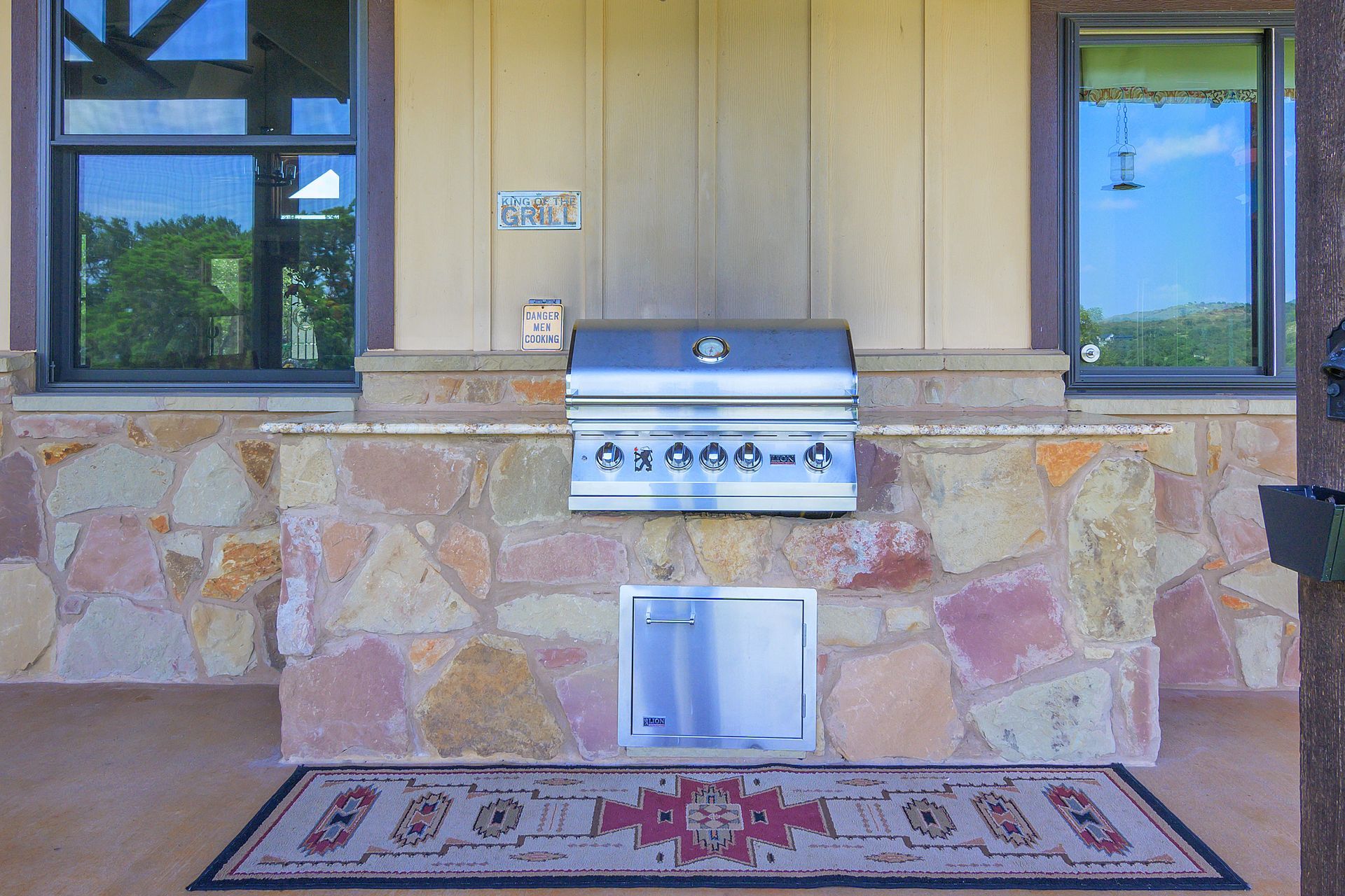 A grill is built into the stone wall of a house