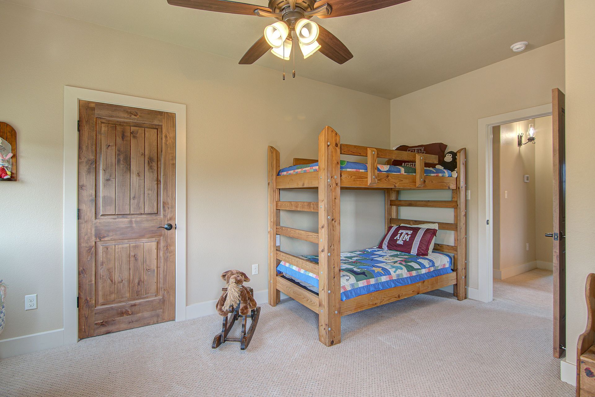 A bedroom with a bunk bed and a ceiling fan.