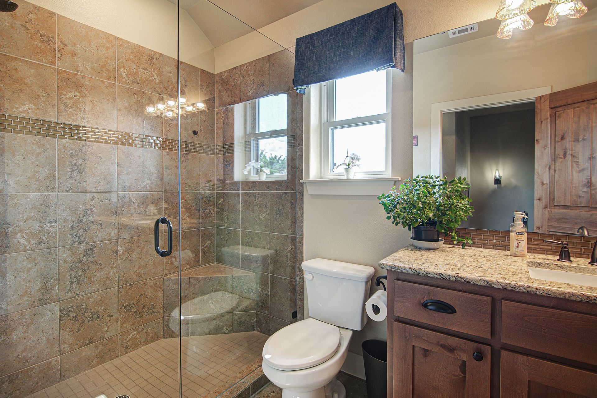 A bathroom with a toilet , sink , and walk in shower.