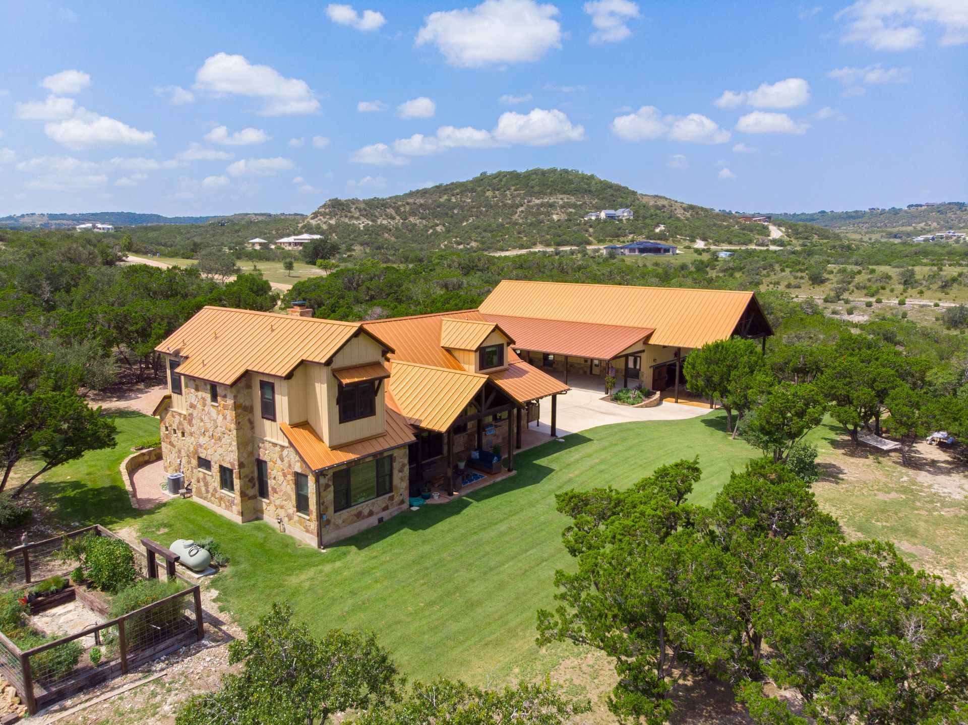 An aerial view of a large house surrounded by trees and grass.