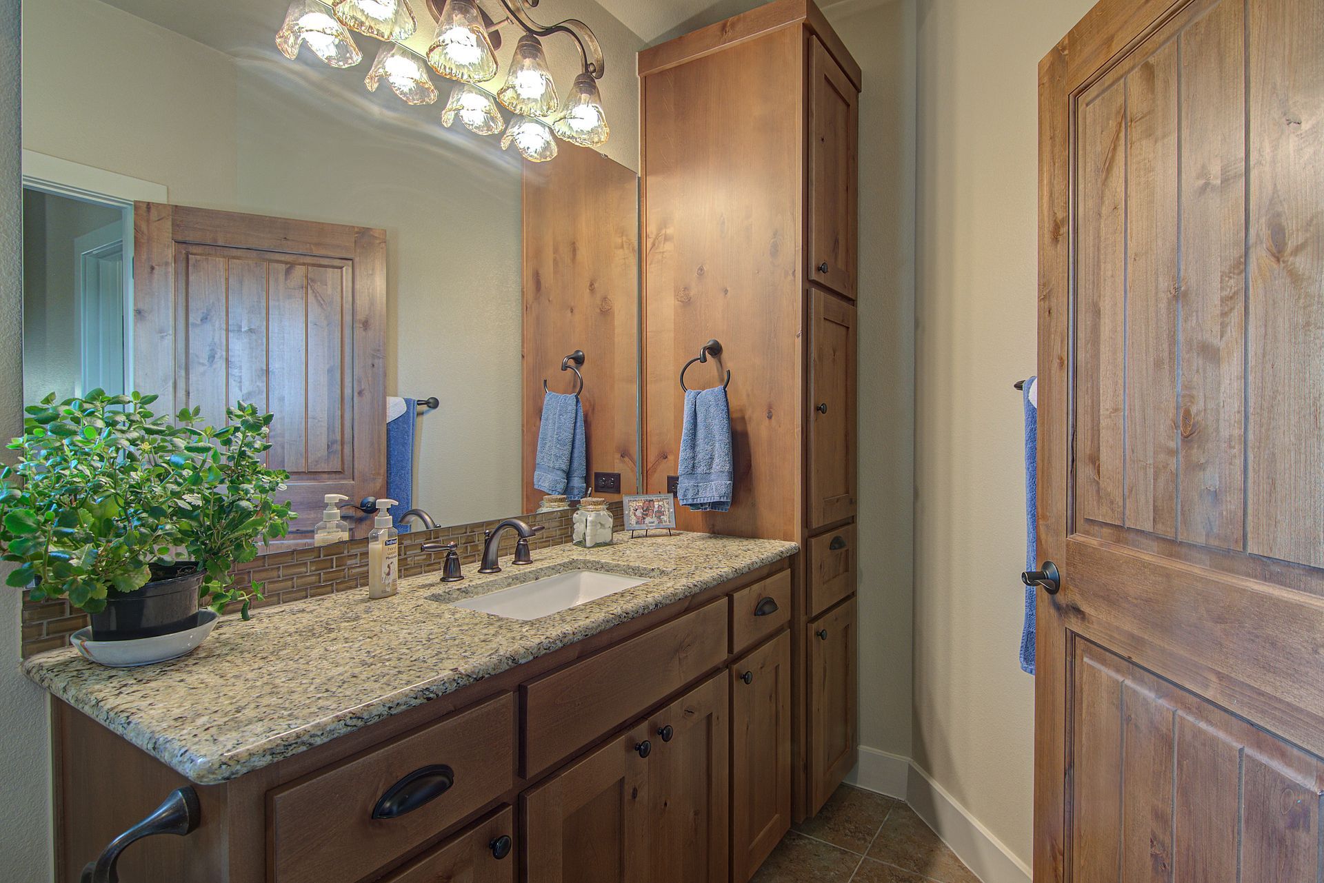 A bathroom with a sink , mirror and cabinets.