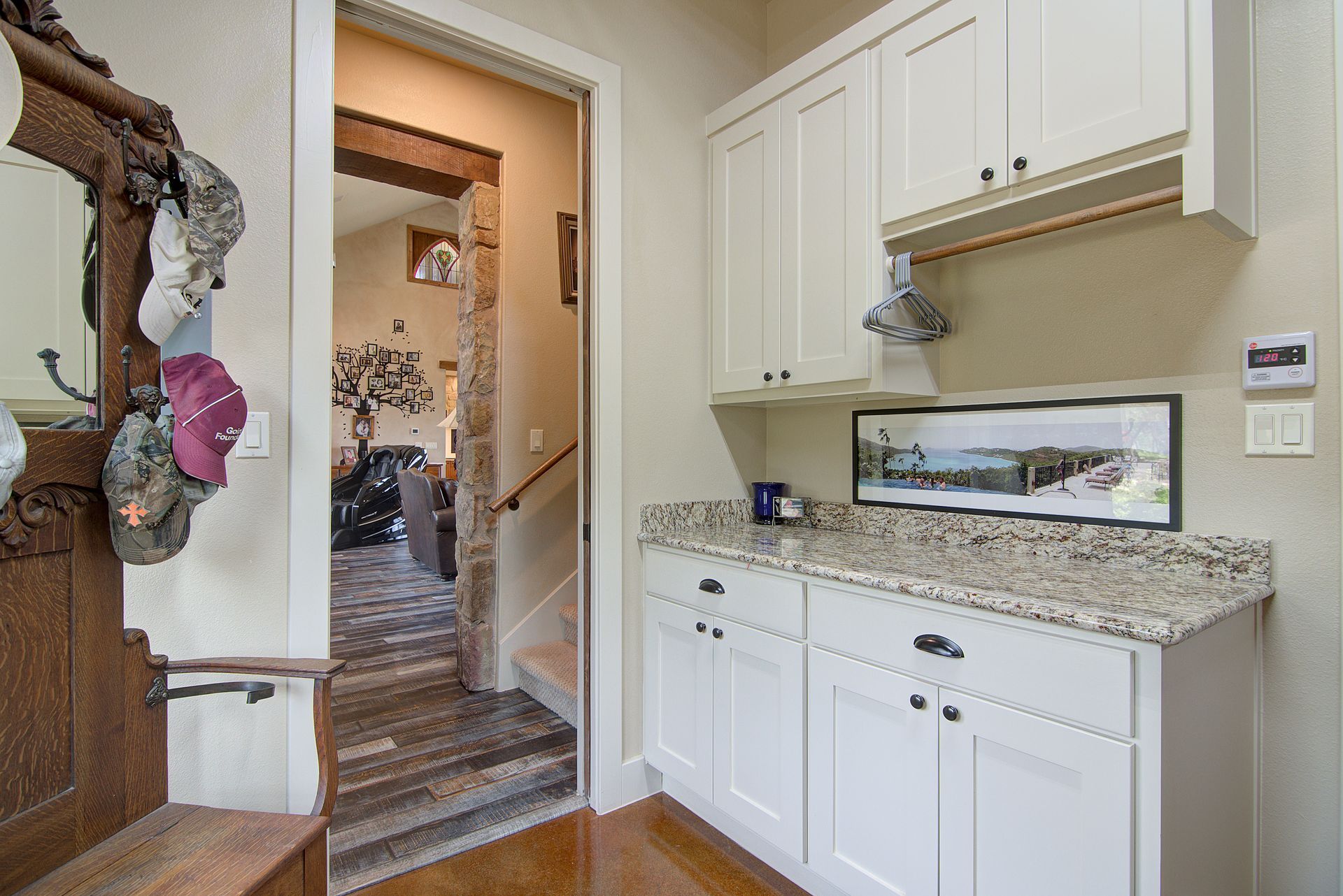 A kitchen with white cabinets and granite counter tops.
