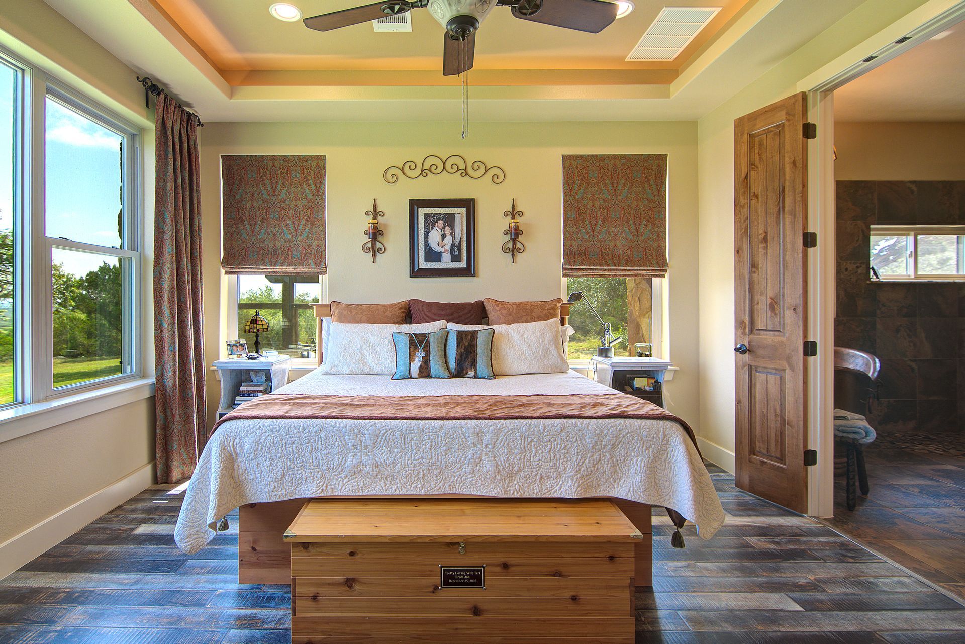 A bedroom with a king size bed and a ceiling fan.