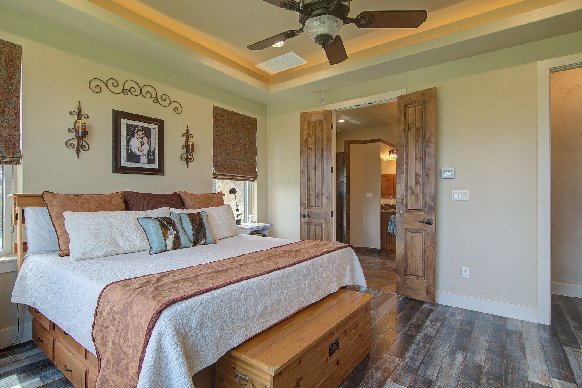 A bedroom with a king size bed and a ceiling fan.
