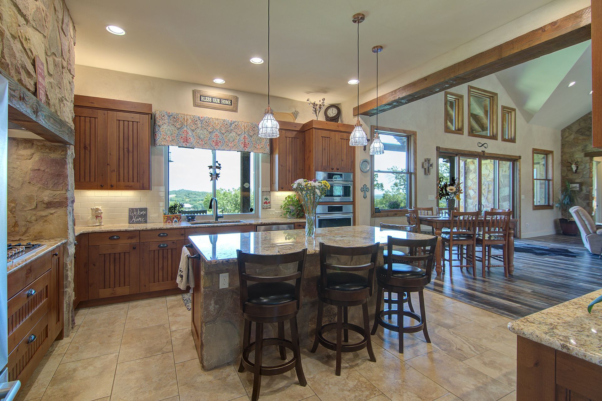 A kitchen with a large island and stools in a house.