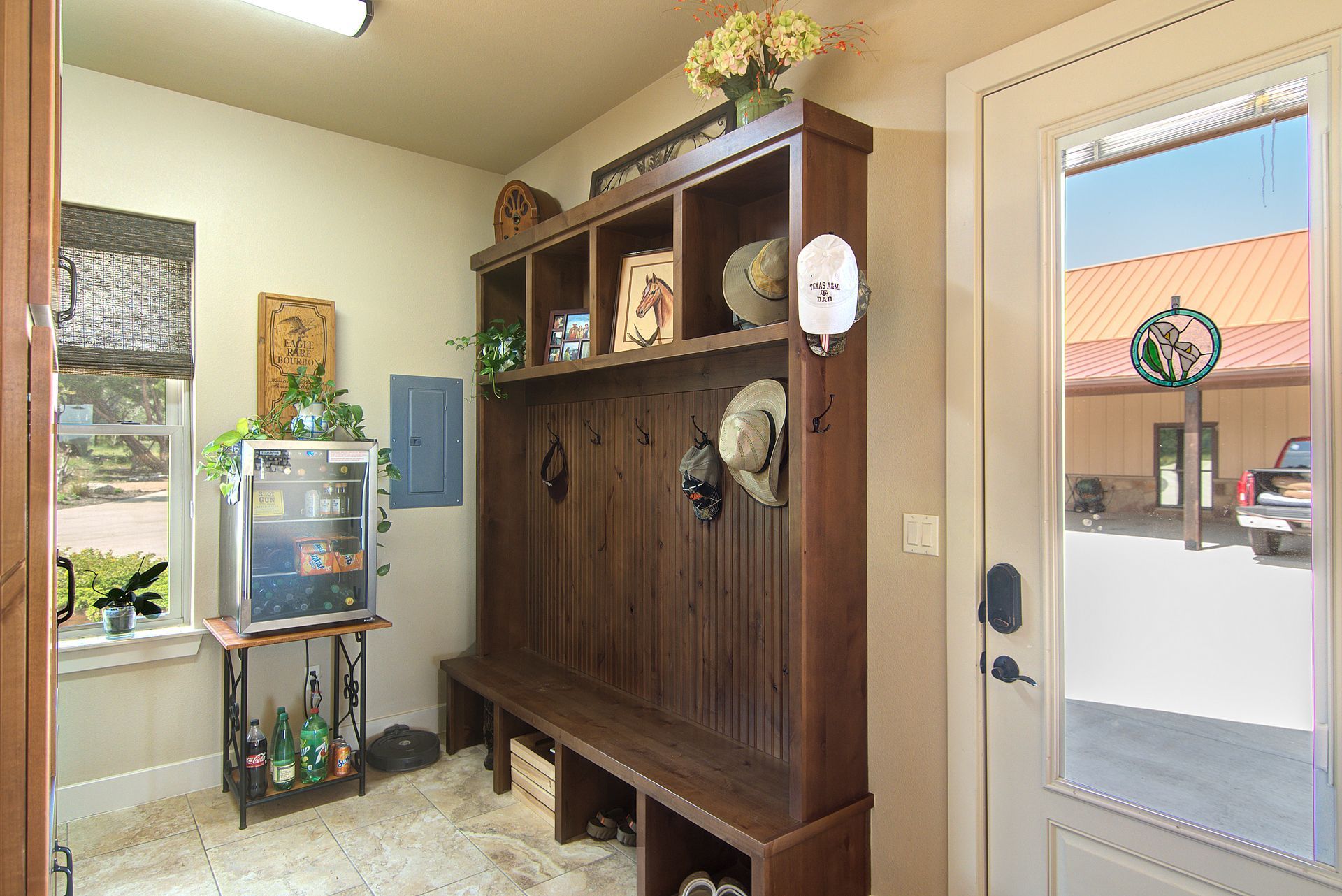 A mud room with a large wooden cabinet and a bench.