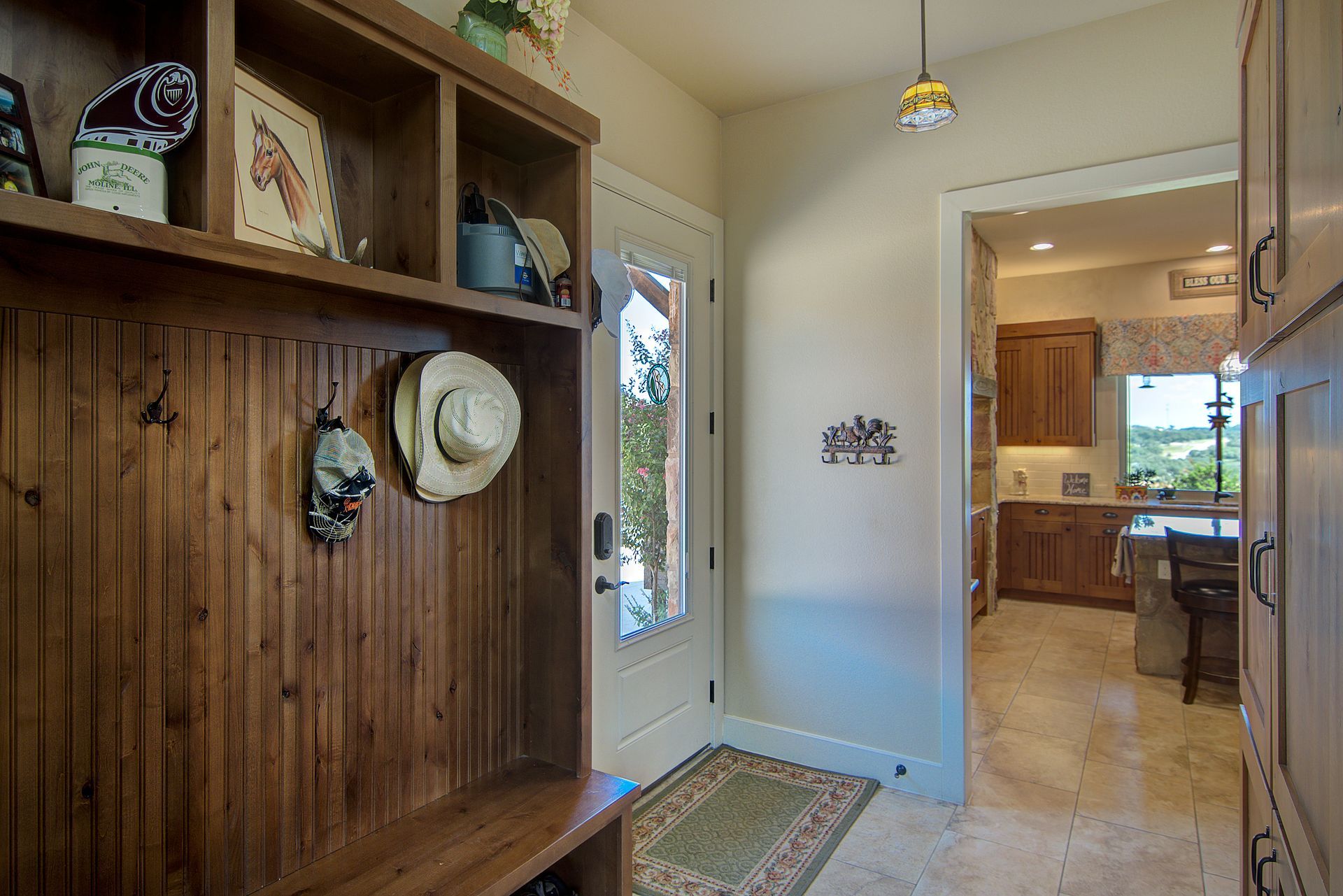 A hallway with a wooden bench and a door leading to a kitchen.