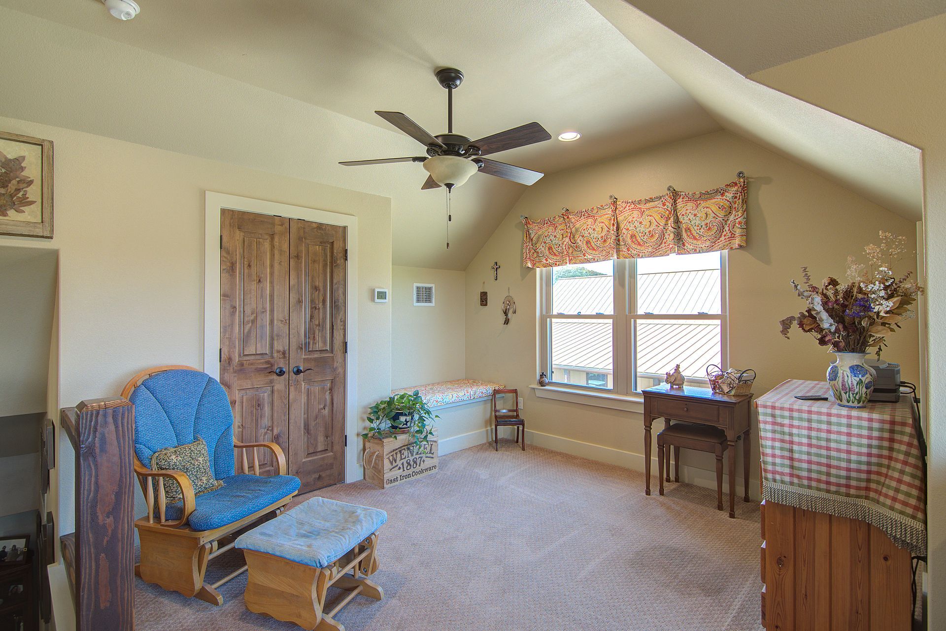 A living room with a blue chair and a ceiling fan