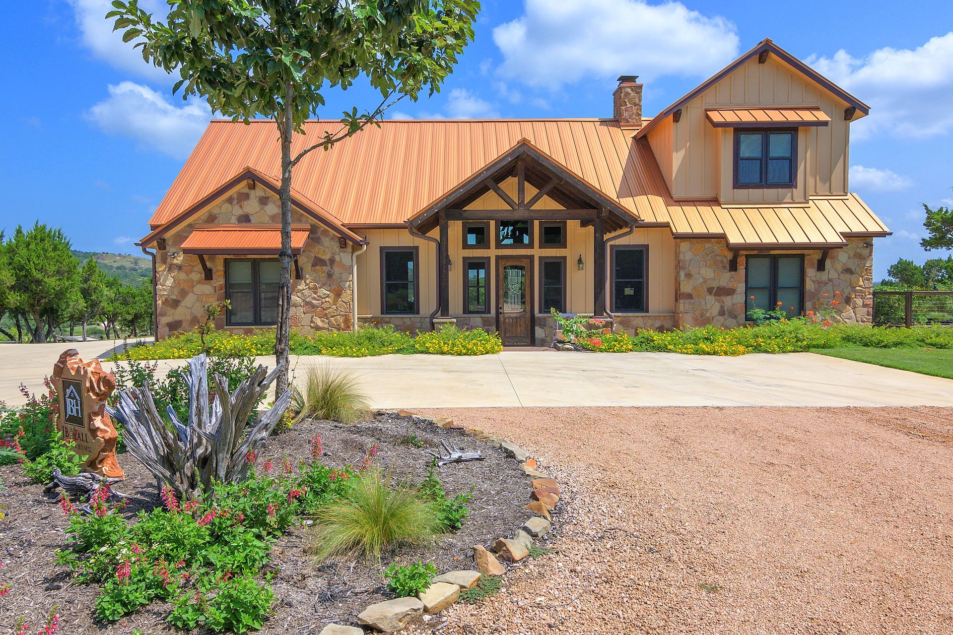A large house with a driveway and a tree in front of it