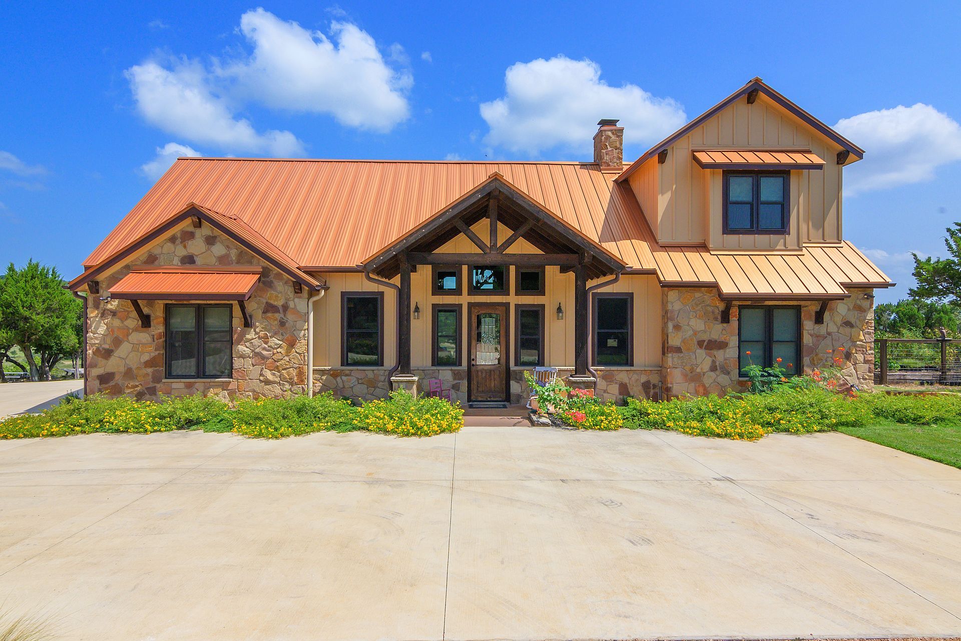 A large house with a red roof and a concrete driveway
