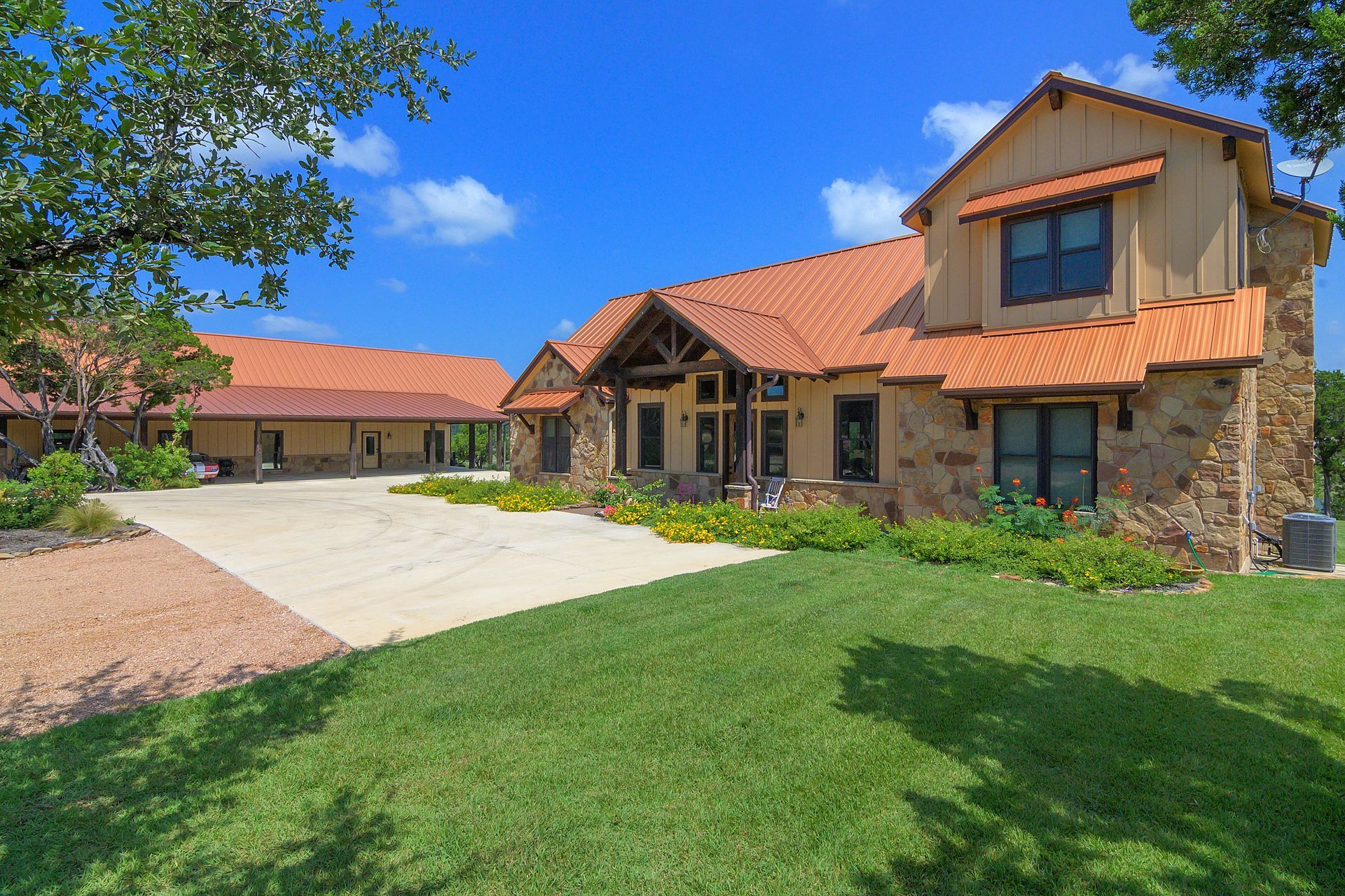 A large house with a red tile roof is sitting on top of a lush green field.