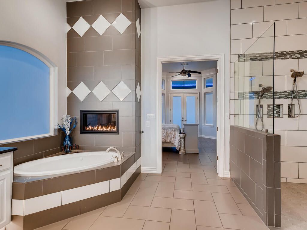 A bathroom with a tub and a fireplace in the corner