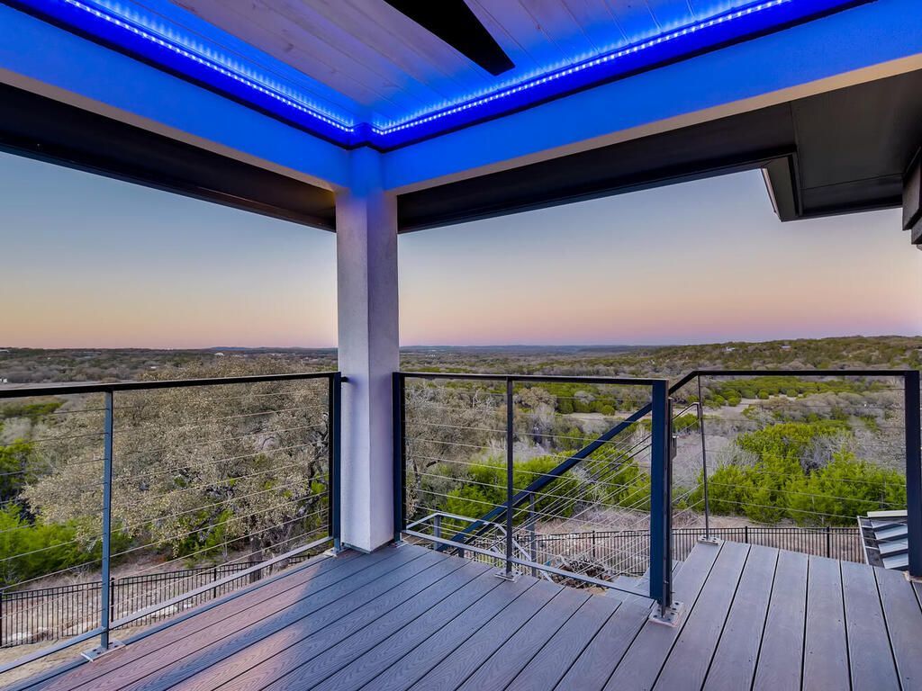 A balcony with a view of a valley and trees.
