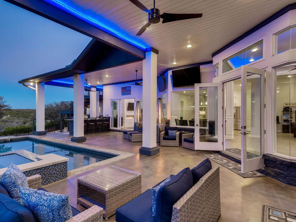 A large house with a swimming pool and patio furniture.