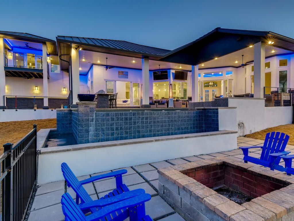 There is a fire pit in front of a large house.