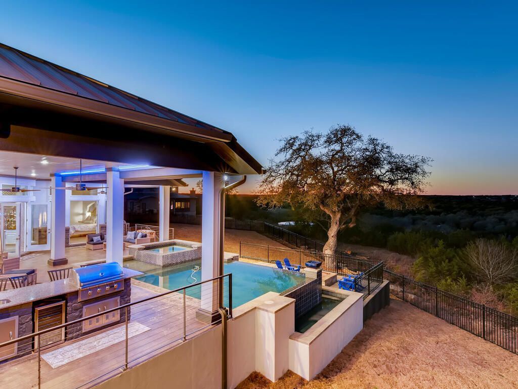 There is a large swimming pool in the backyard of a house.
