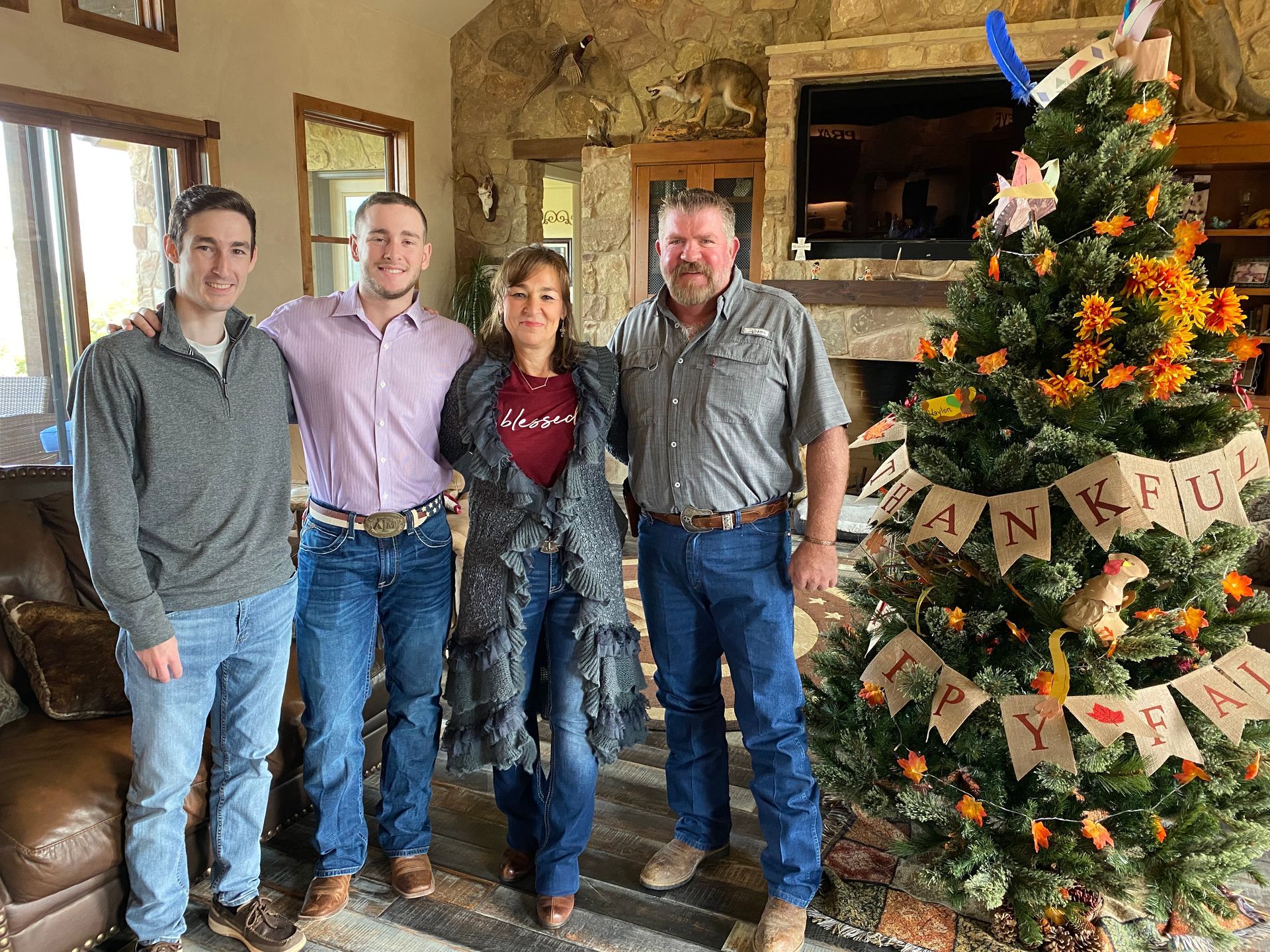 Hall Family Picture The family of J B Hall Custom Homes is posing for a family picture in front of a christmas tree.