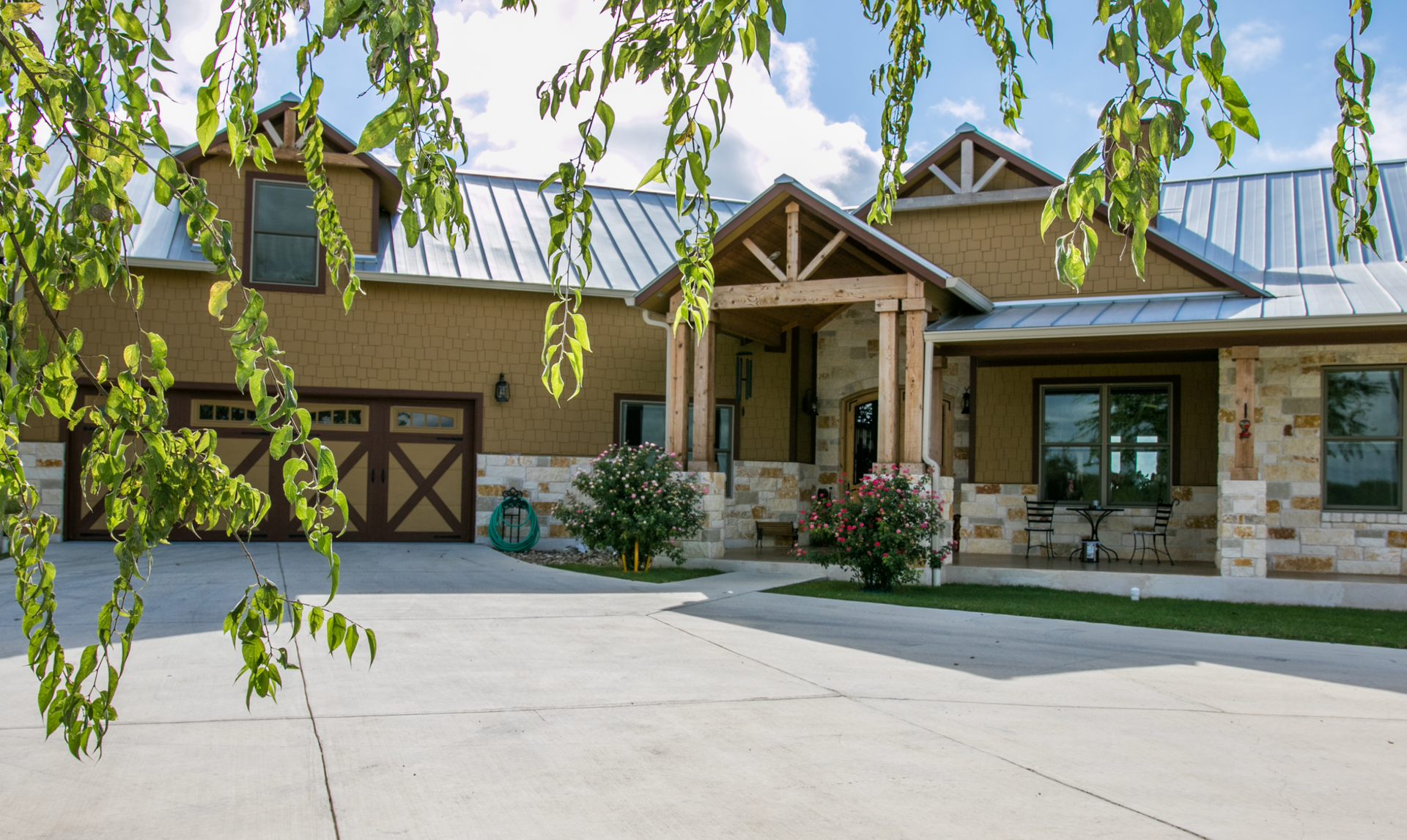 A large house with a garage and a tree in front of it