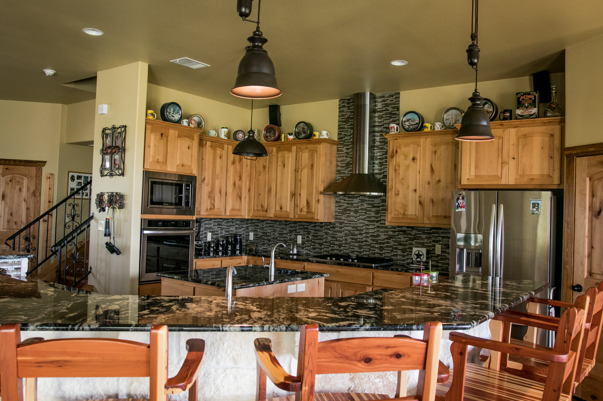 A kitchen with wooden cabinets , granite counter tops , and stainless steel appliances.