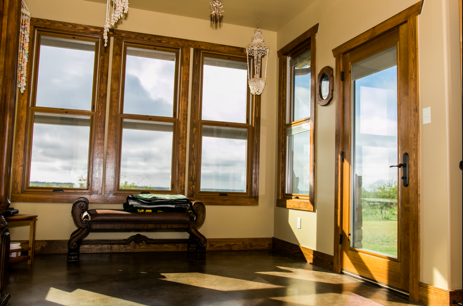 A room with a bench and a lot of windows