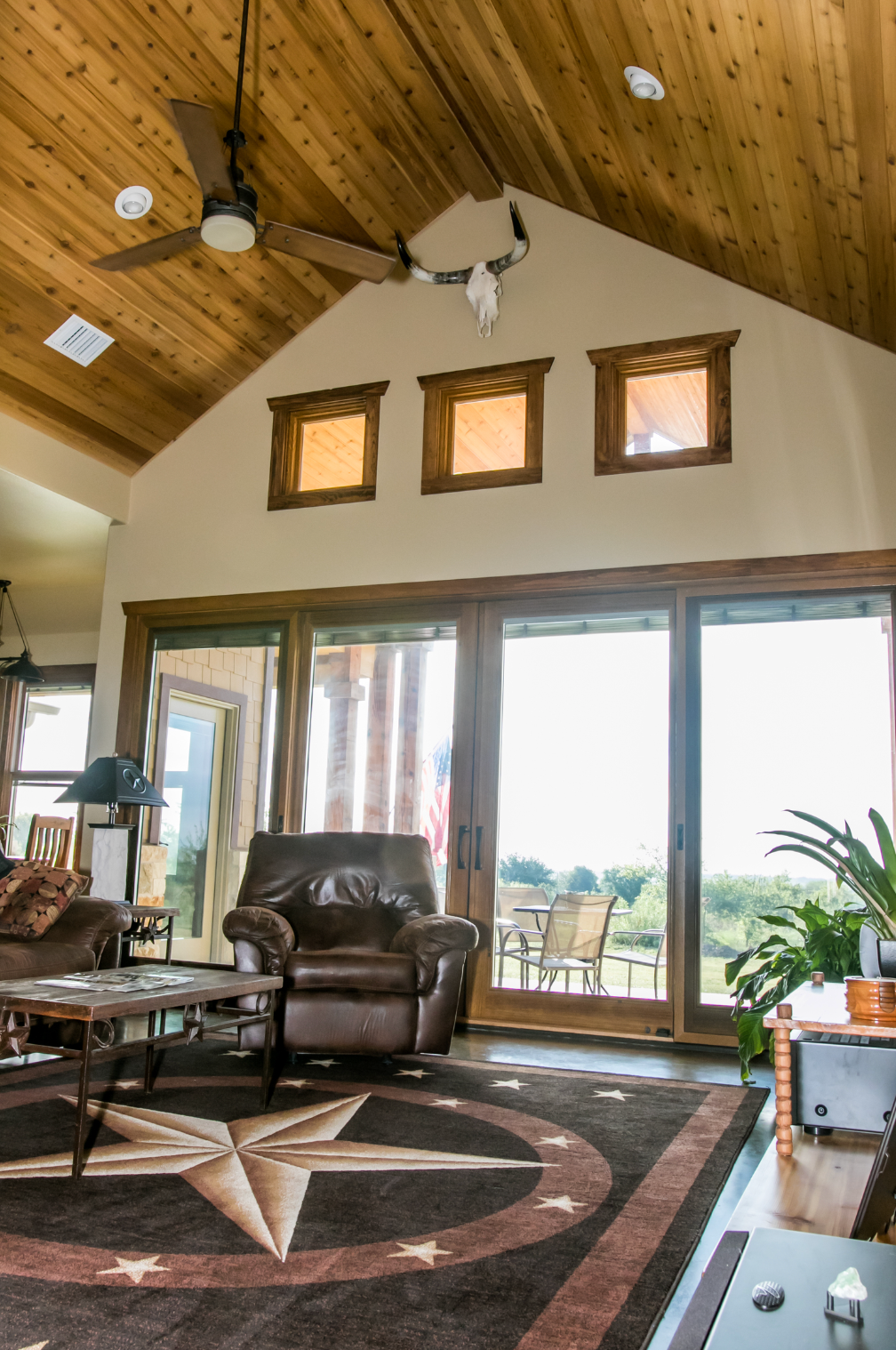 A living room with a vaulted ceiling and sliding glass doors