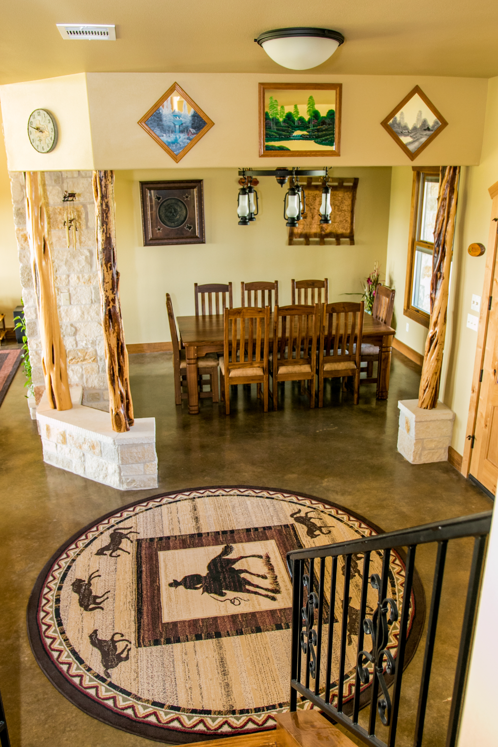 A dining room with a table and chairs and a rug