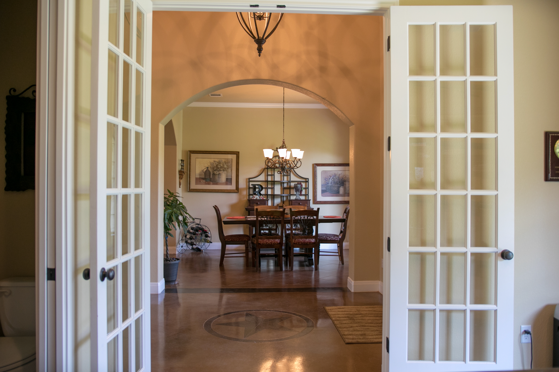 French doors open to a dining room with a table and chairs