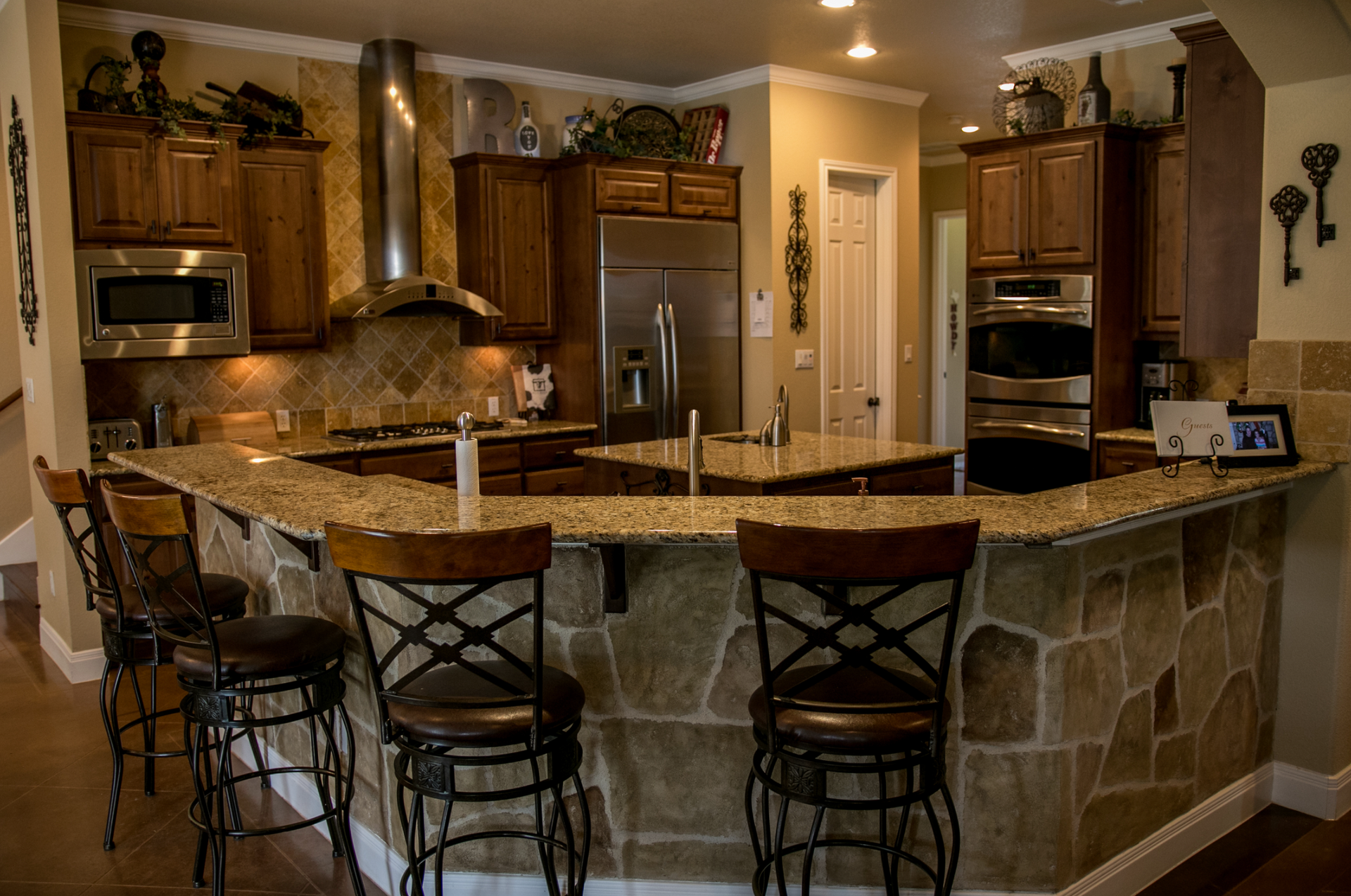 A kitchen with a granite counter top and stools