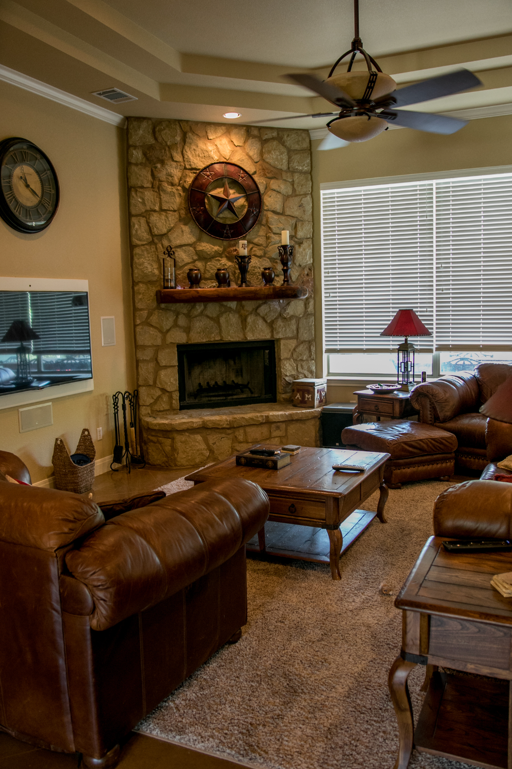 A living room with a fireplace and a ceiling fan.