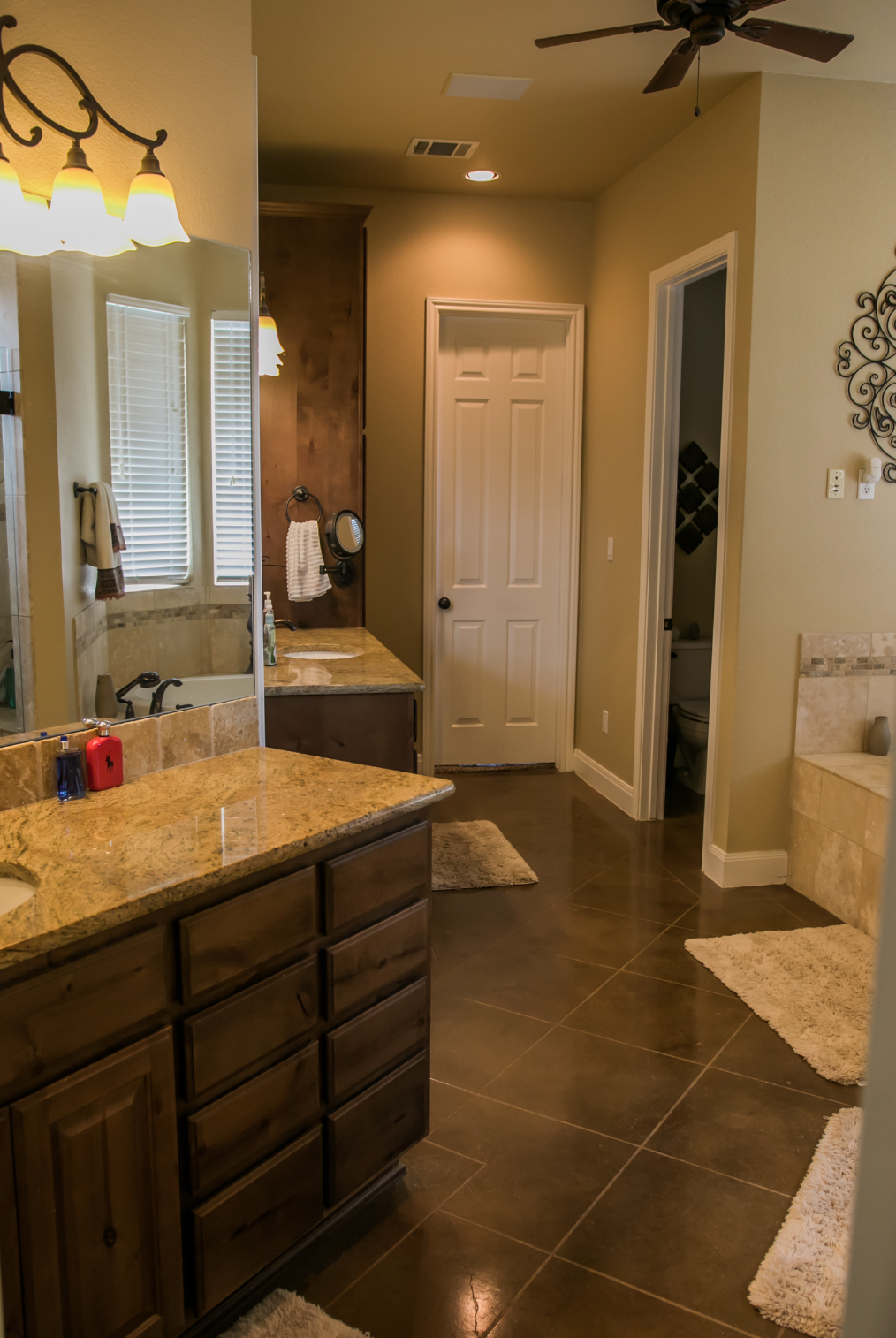 A bathroom with two sinks and a ceiling fan