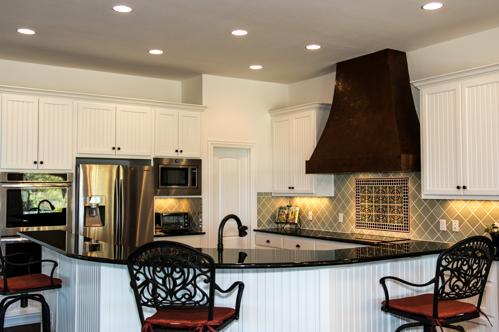 A kitchen with white cabinets and stainless steel appliances
