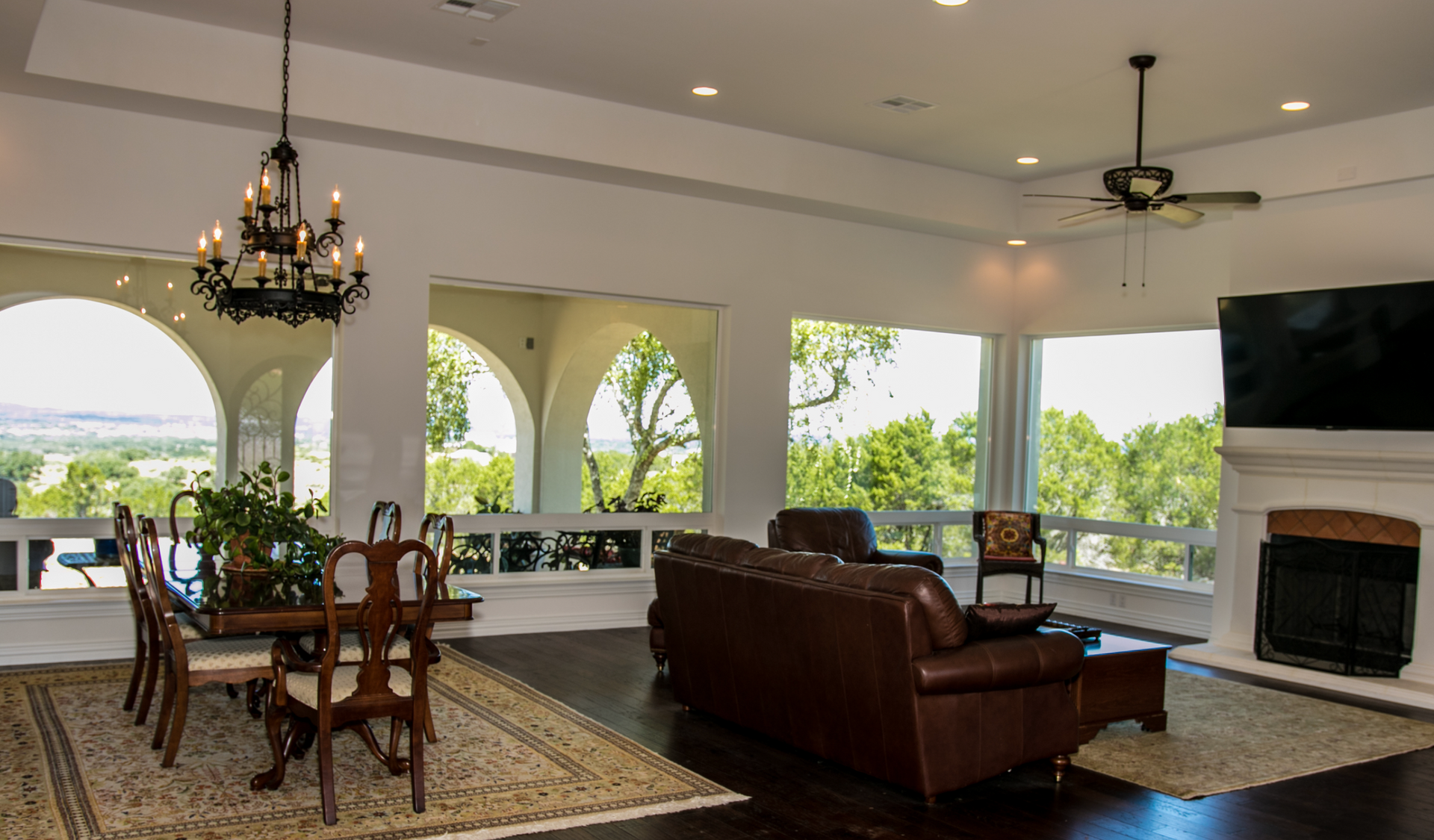 A living room with a couch , table and chairs and a fireplace.