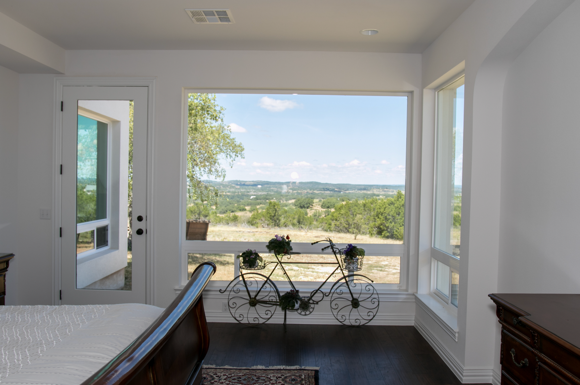 A bedroom with a large window and a bicycle in front of it.