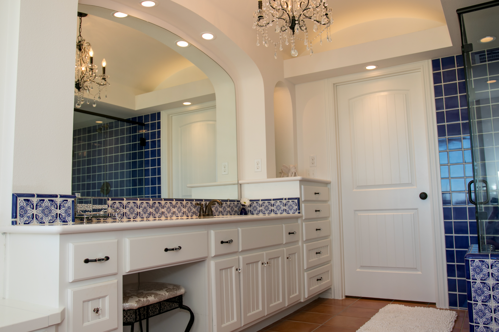 A bathroom with blue and white tiles and a large mirror