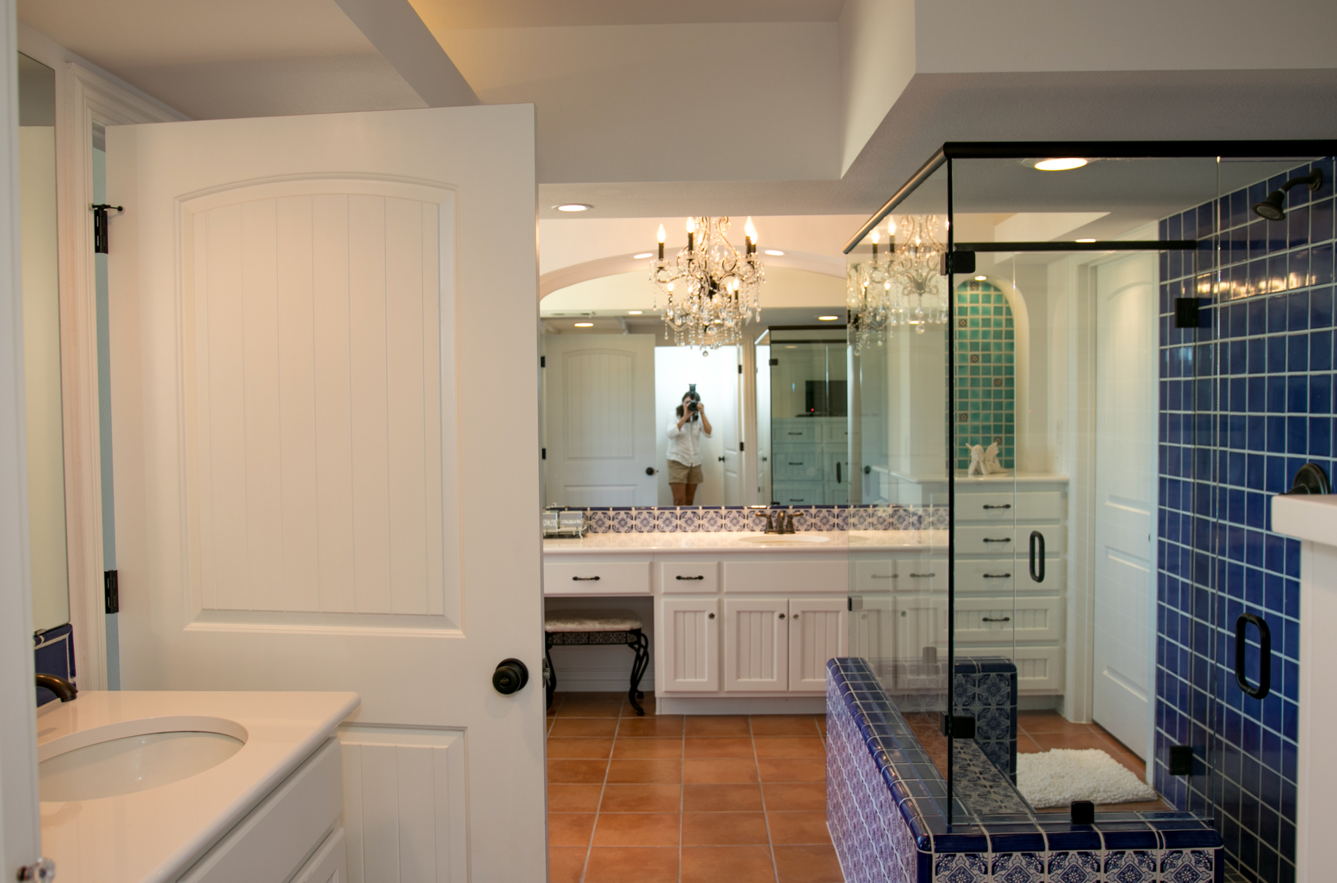 A bathroom with blue tiles and a walk in shower