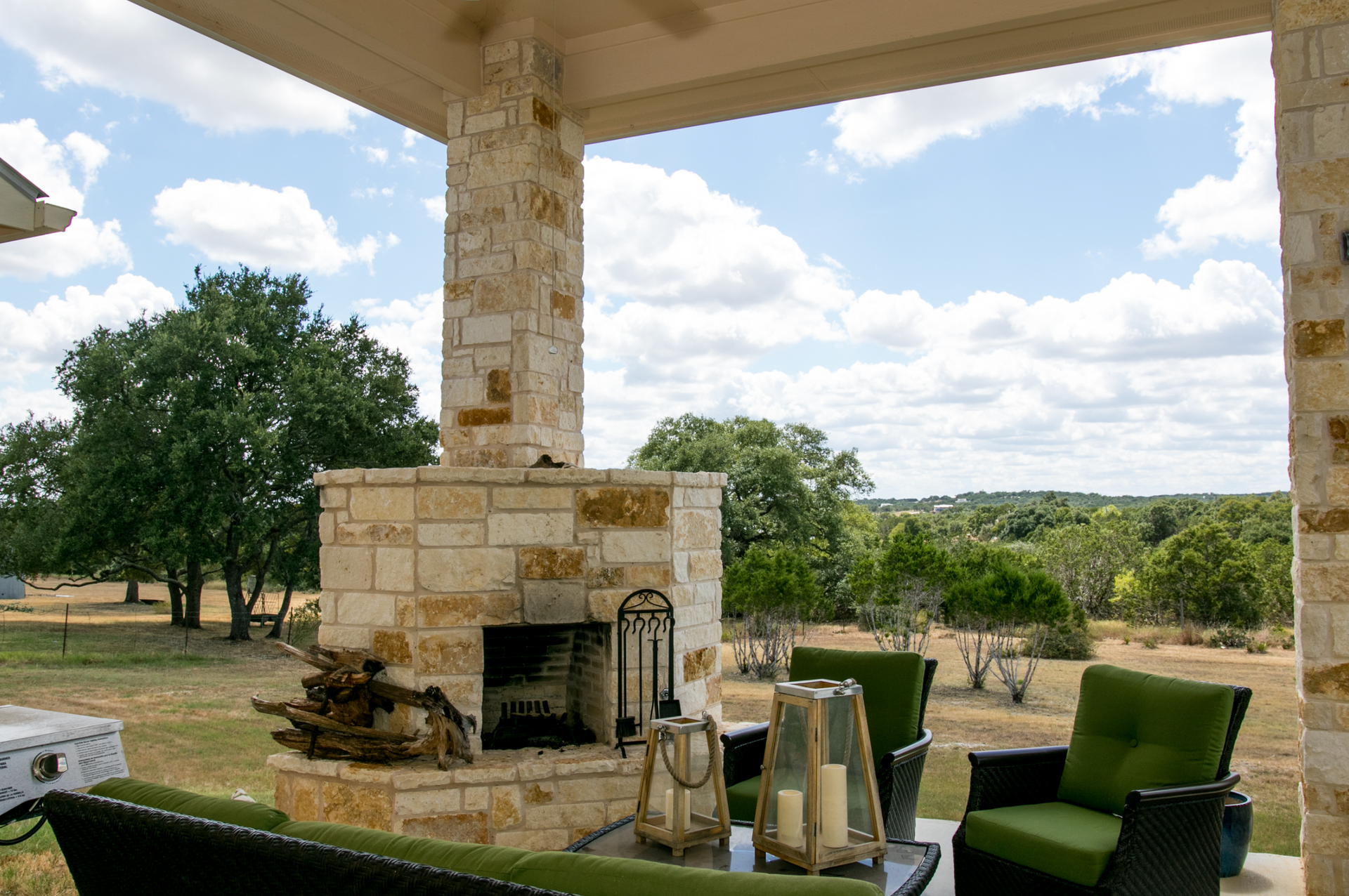 A patio with a fireplace and a couch and chairs