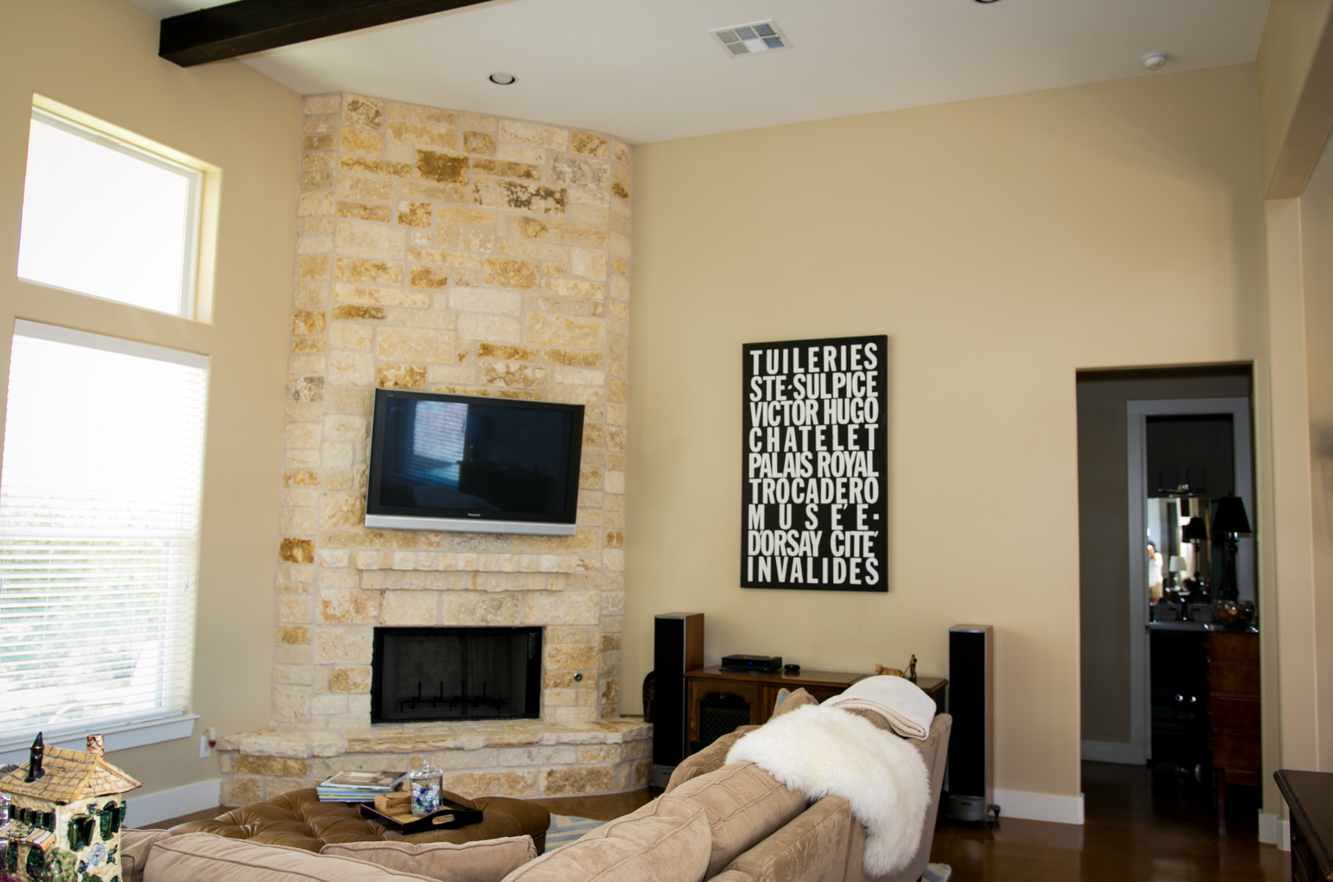 A living room with a fireplace and a flat screen tv on the wall.
