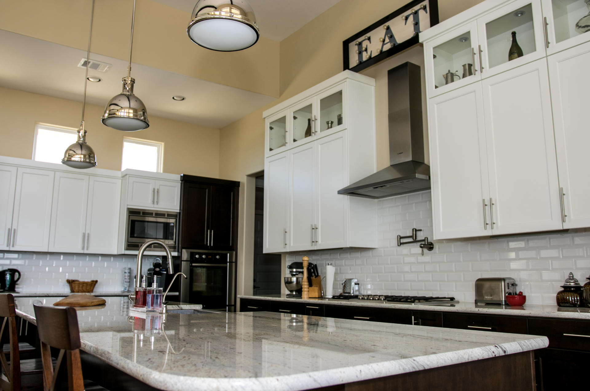 A kitchen with white cabinets and a large island.