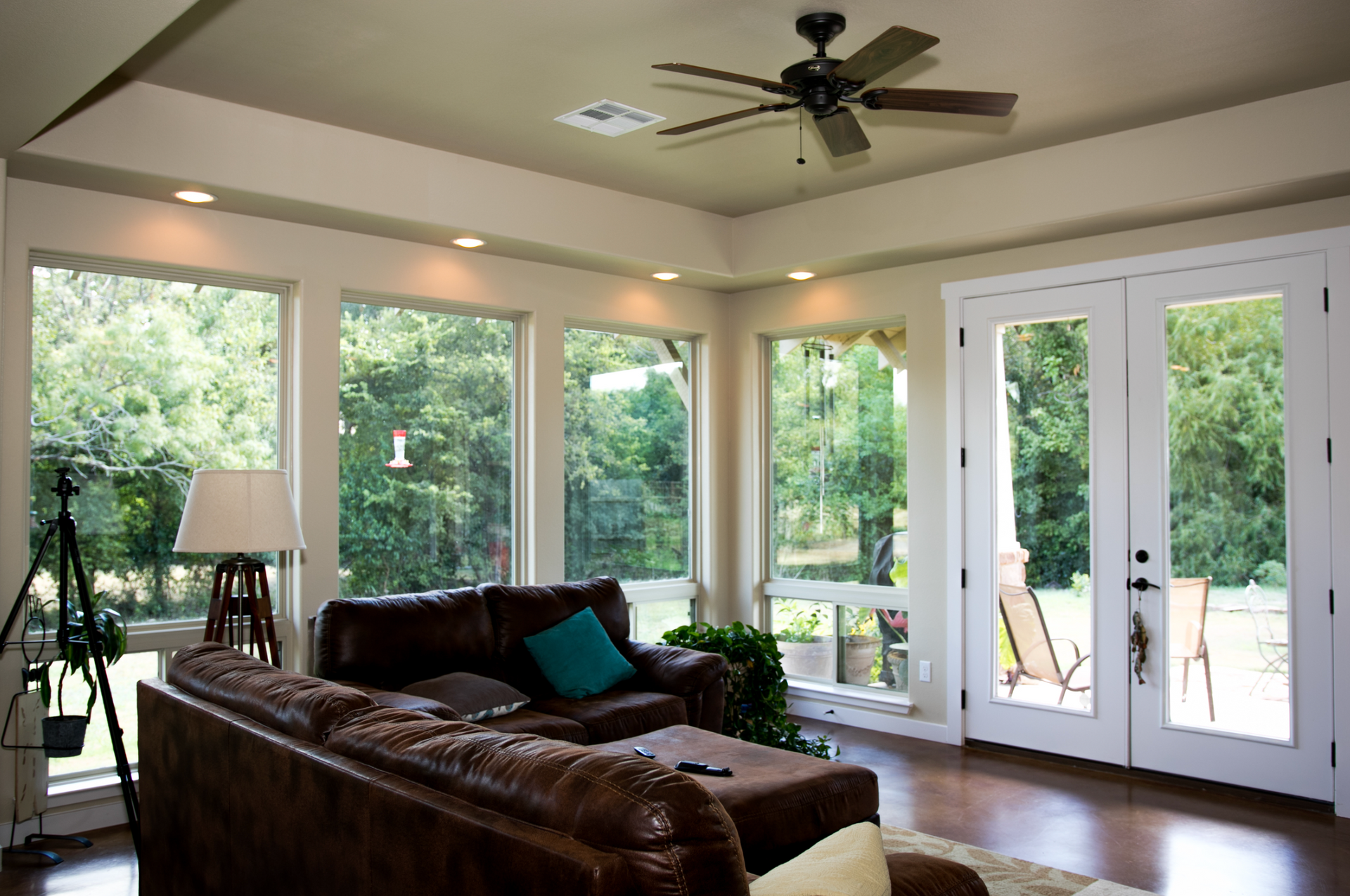 A living room with a brown couch and a ceiling fan
