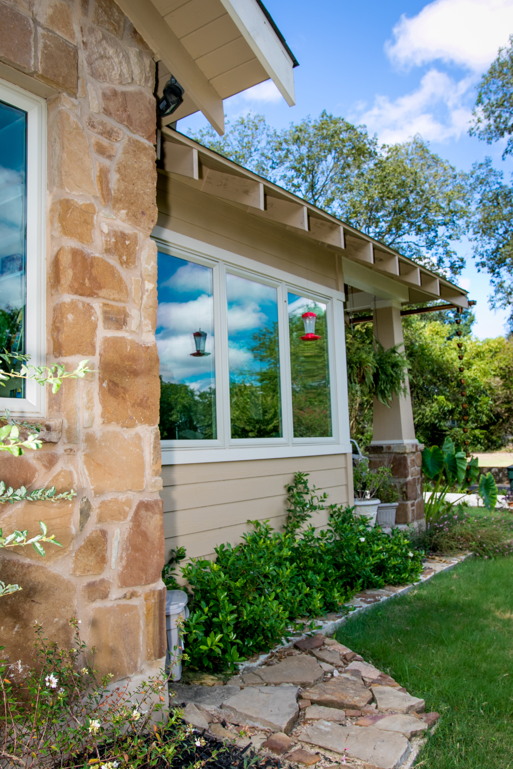 A house with a stone wall and a walkway leading to it