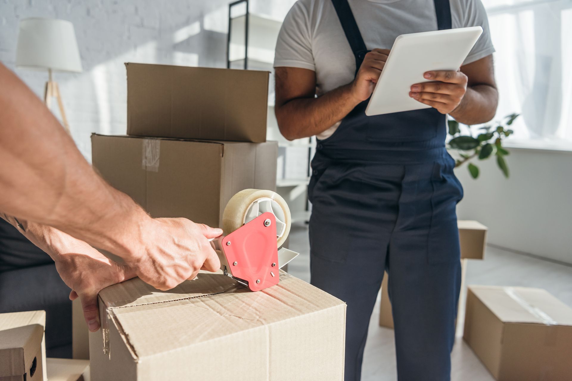 Two movers are packing boxes.