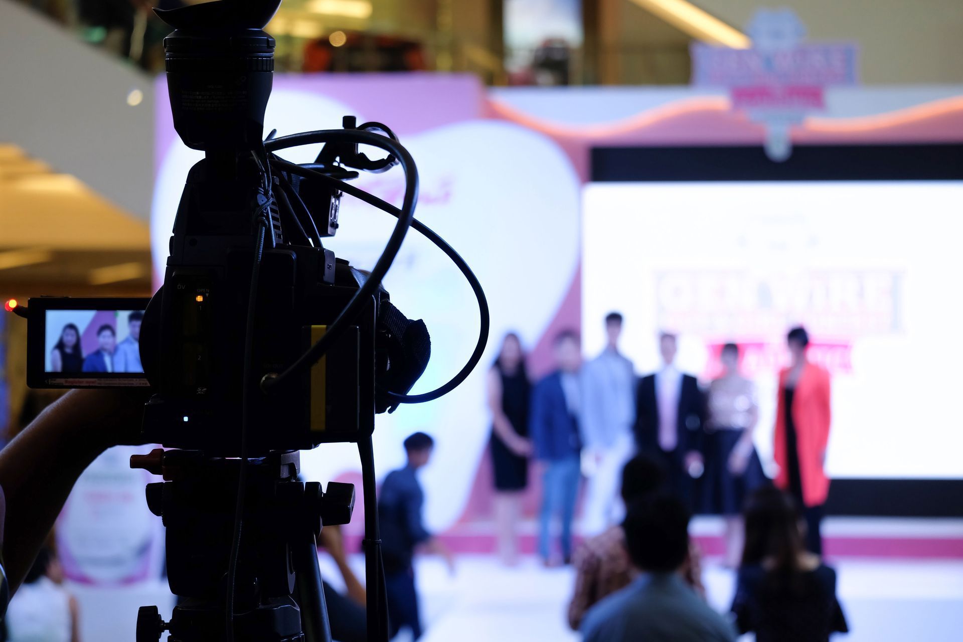 A person is holding a video camera in front of a group of people .