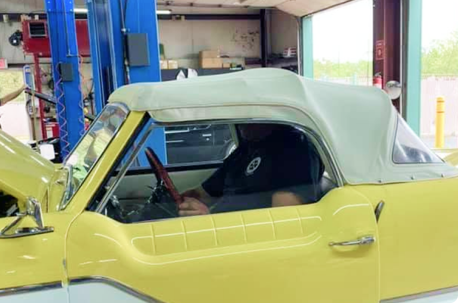 Yellow convertible car with beige soft top in an auto repair shop | Denton Auto Care And Tire