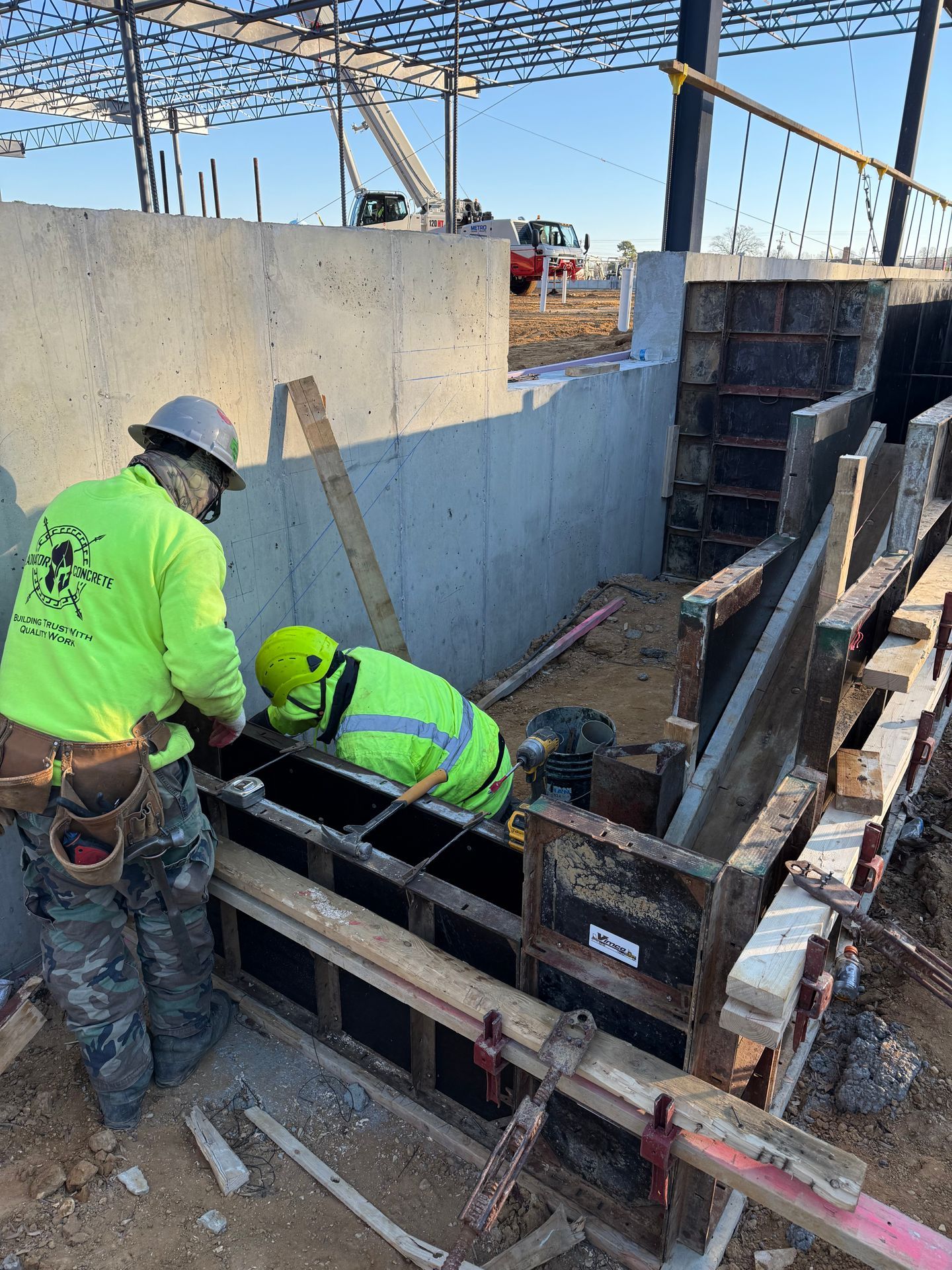 Construction workers pouring concrete into a form on a building site
