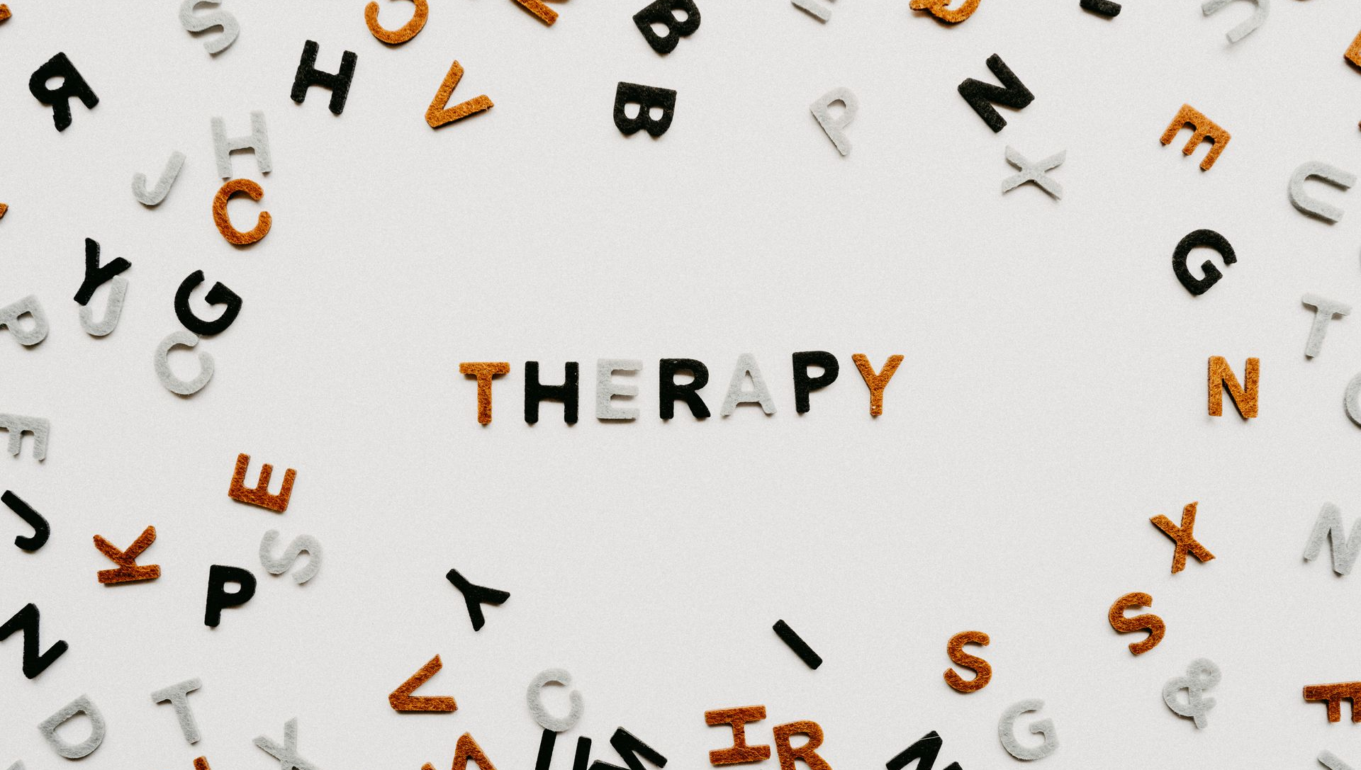 Letters scattered around the word “THERAPY” on a white background.