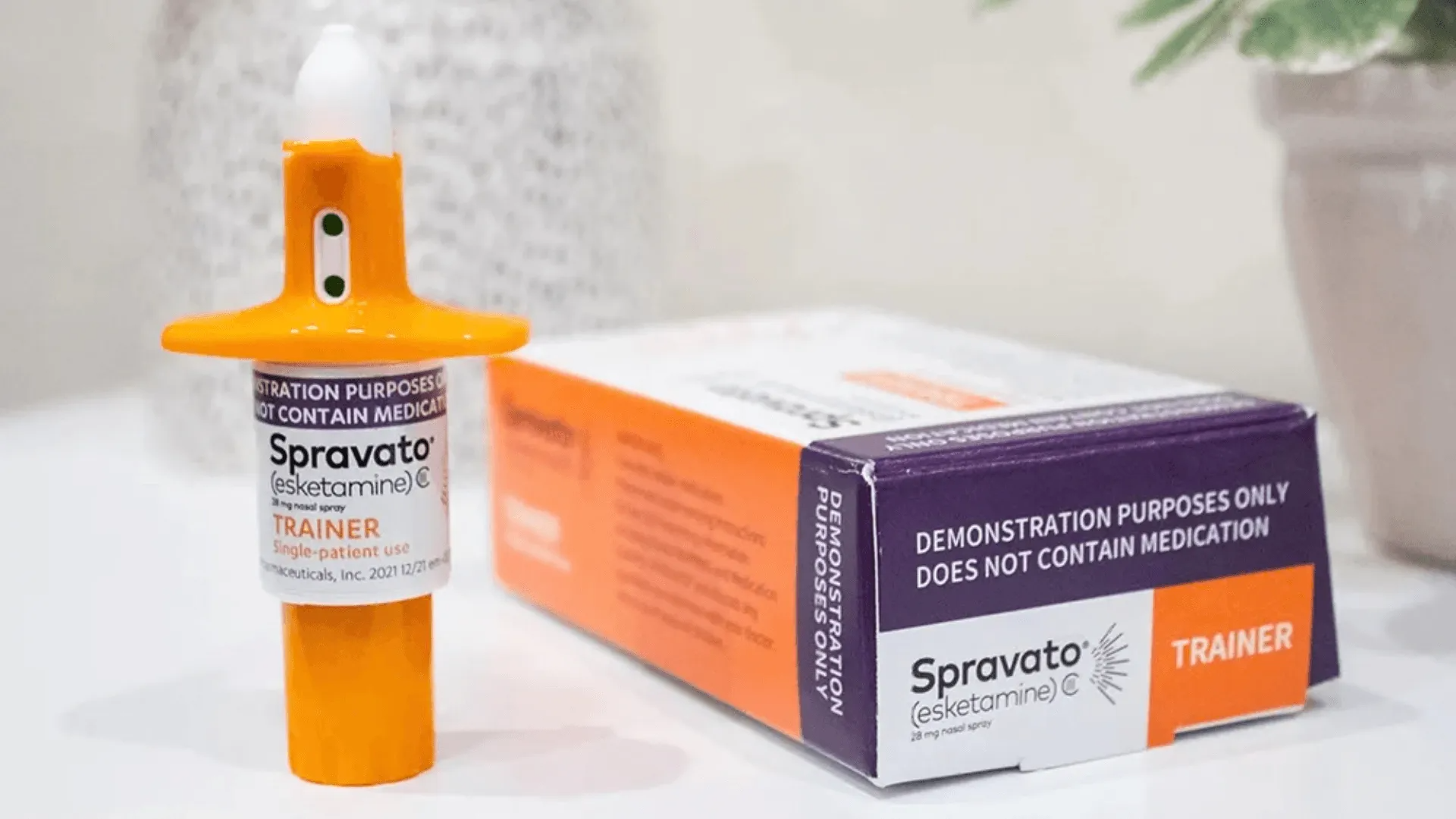 Spravato nasal spray bottle and orange-and-white box on a light surface